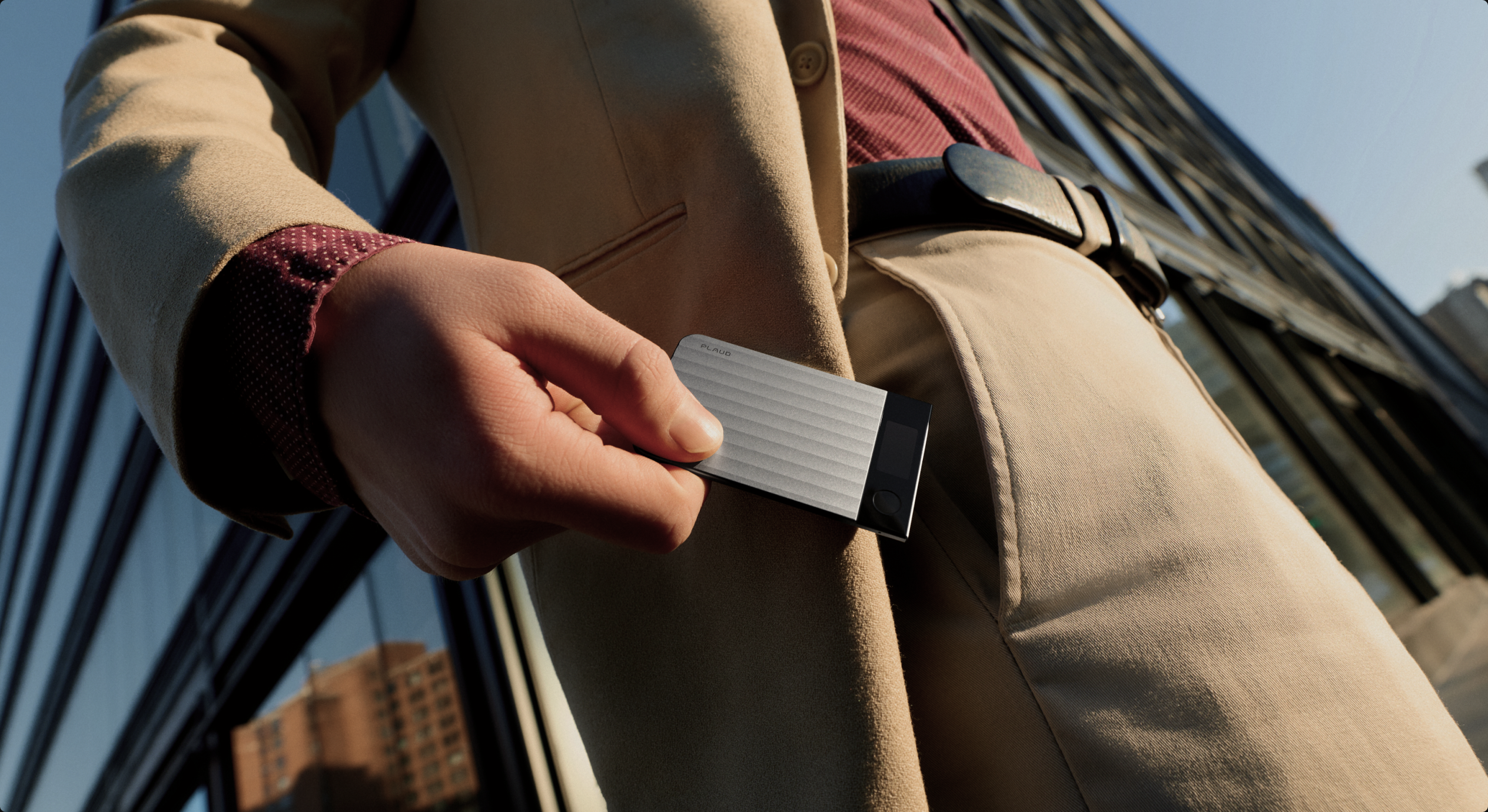 A person slipping the Plaud Note Pro into a jacket pocket